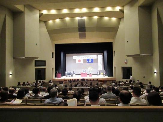 愛知県市町村教育委員会連合会第51回定期総会及び研修会にて壇上で演説する人の話しをきいている人たちの写真