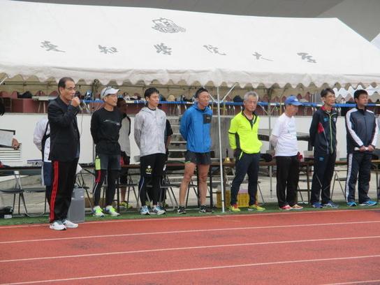 愛知学院大学にて第2回陸上競技記録会の開会式が行われ挨拶している人の横に整列している人たちの写真