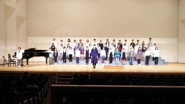 日進市小中学校音楽発表会の複数の生徒が壇上で歌を歌っている写真