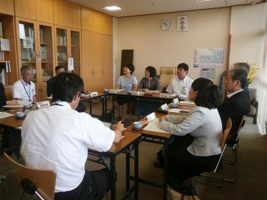 森本教育長職務代理者と鈴木委員、藤井委員が赤池小学校を訪問した際の机を挟んで話をしている写真