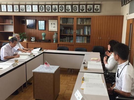 森本教育長職務代理者と鈴木委員が北小学校を訪問し机を挟んで会話をしている写真