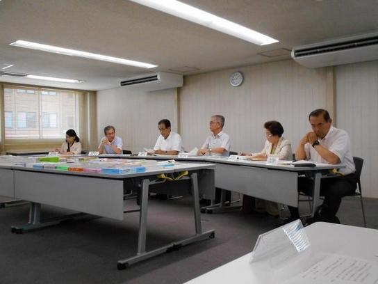 日進市役所にて7月臨時教育委員会を開催した際に机の前に座っている6名の写真