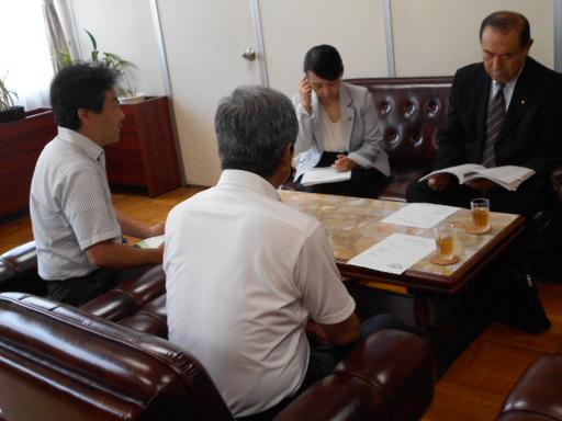 藤井委員と小林委員が日進東中学校を訪問し、応接室で背中を向けて男性2名、正面に左に女性、右に男性が座っている写真