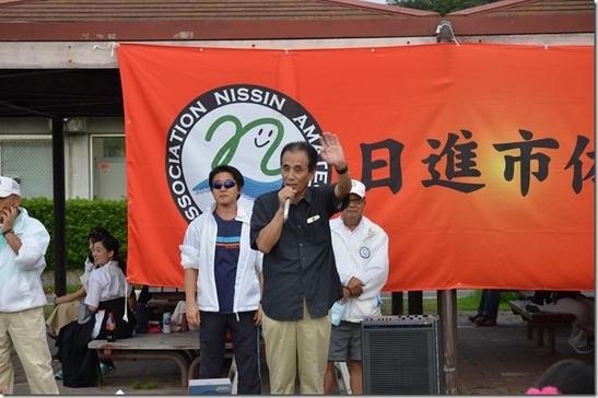 日進市総合運動公園にて平成30年度体協まつりアウトドアすぽーつ体験会が開催され、横断幕の前で演説している様子の写真