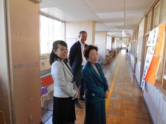 成田教育長職務代理者と藤井委員が相野山小学校を訪問し廊下で職員に説明をうけている様子の写真