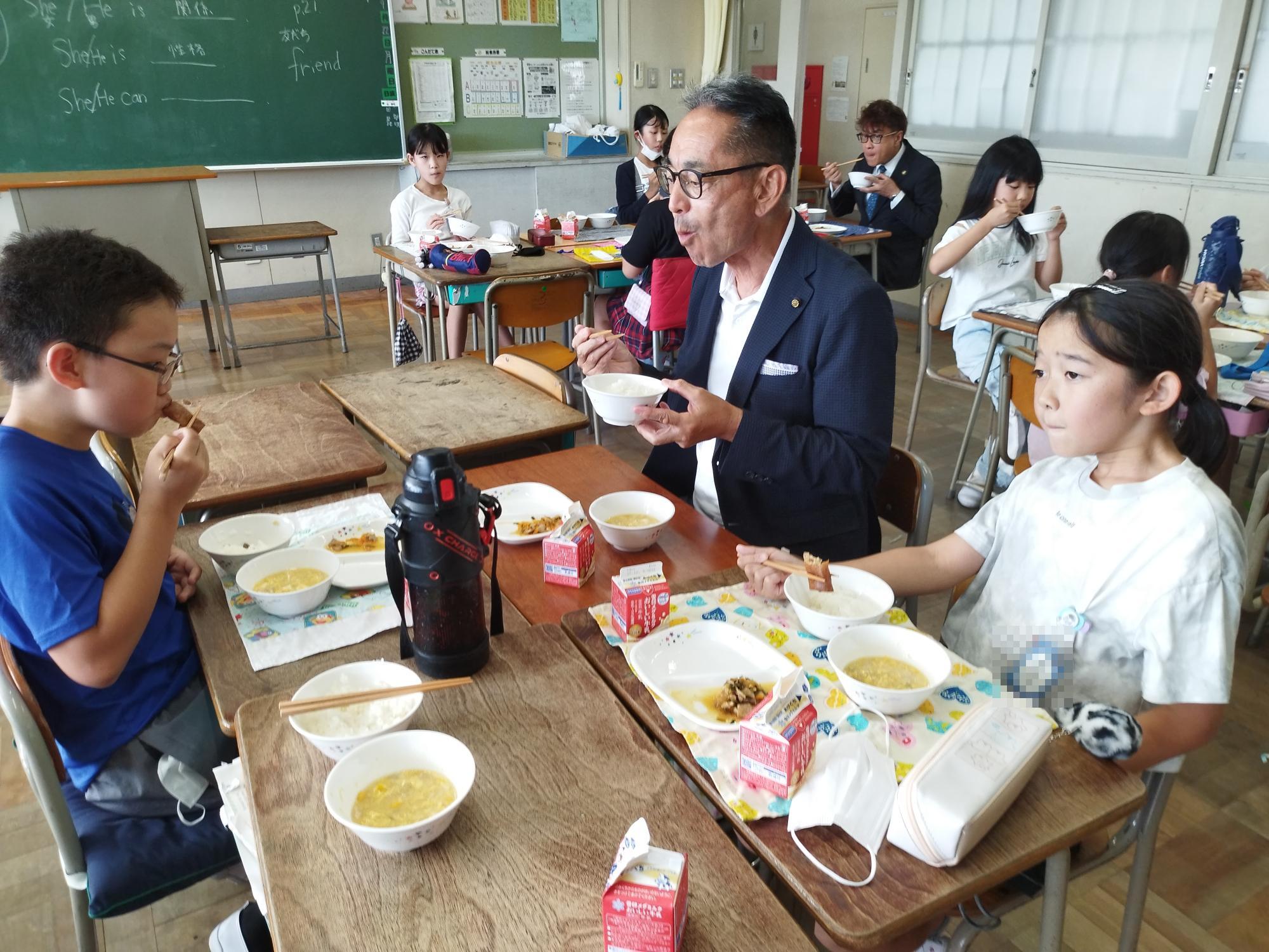 教育長と児童が一緒に給食を食べる様子