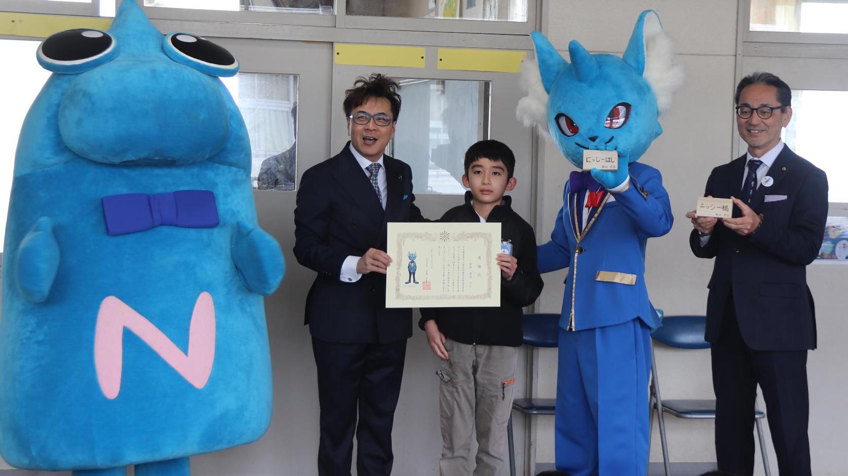にっしーと市長と教育長と受賞児童の集合写真