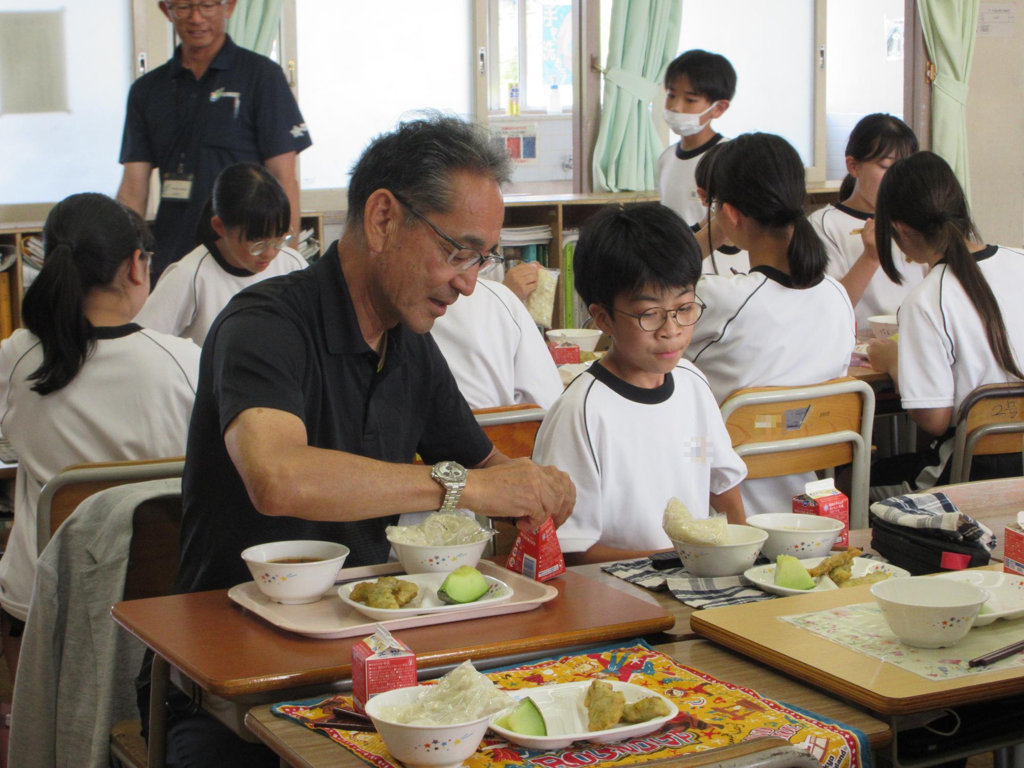 一緒に給食を食べる教育長と生徒