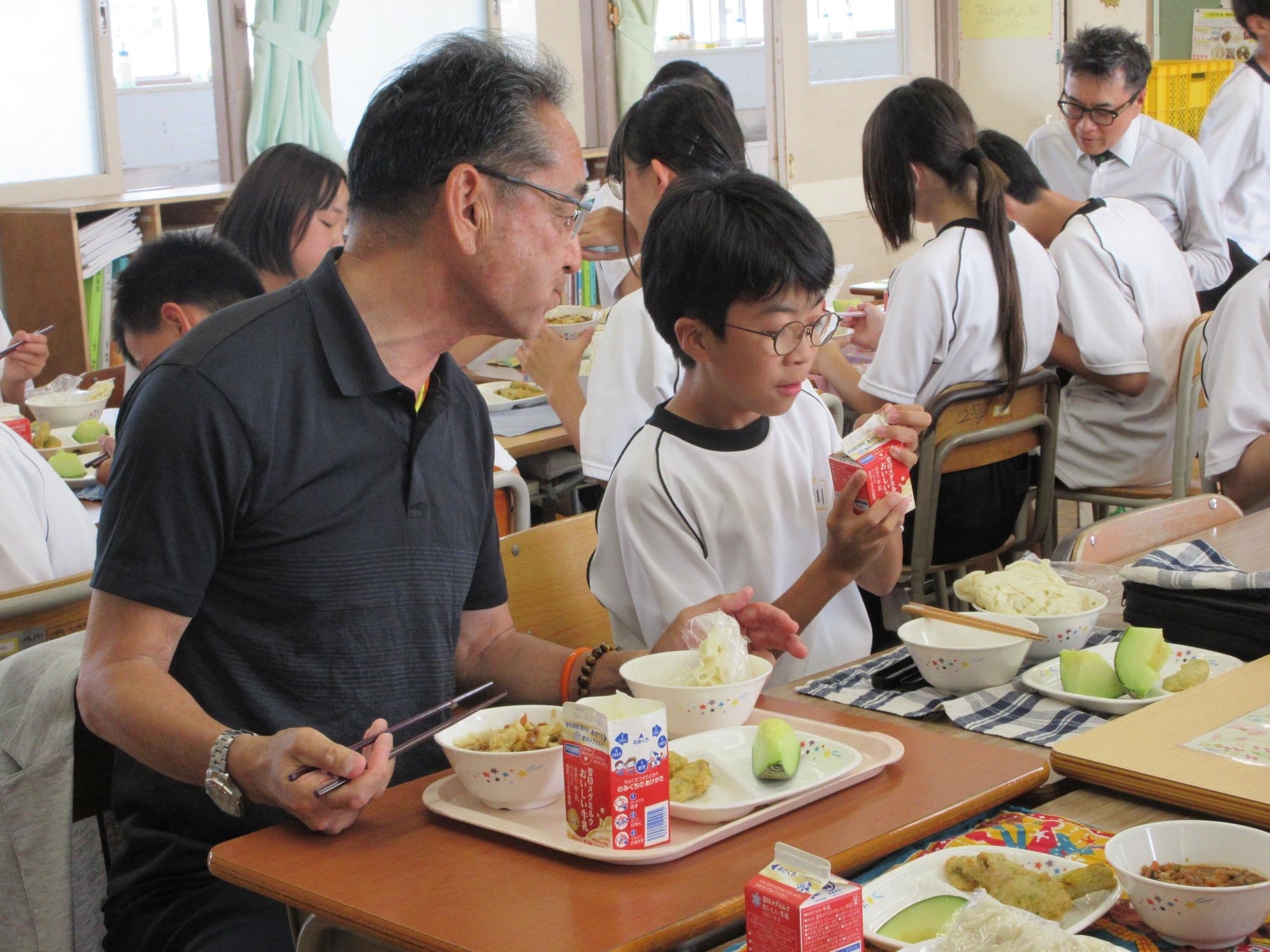 一緒に給食を食べる教育長と生徒