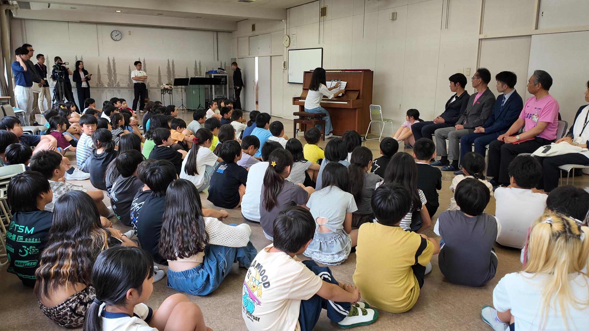 寄贈されたピアノを演奏する児童
