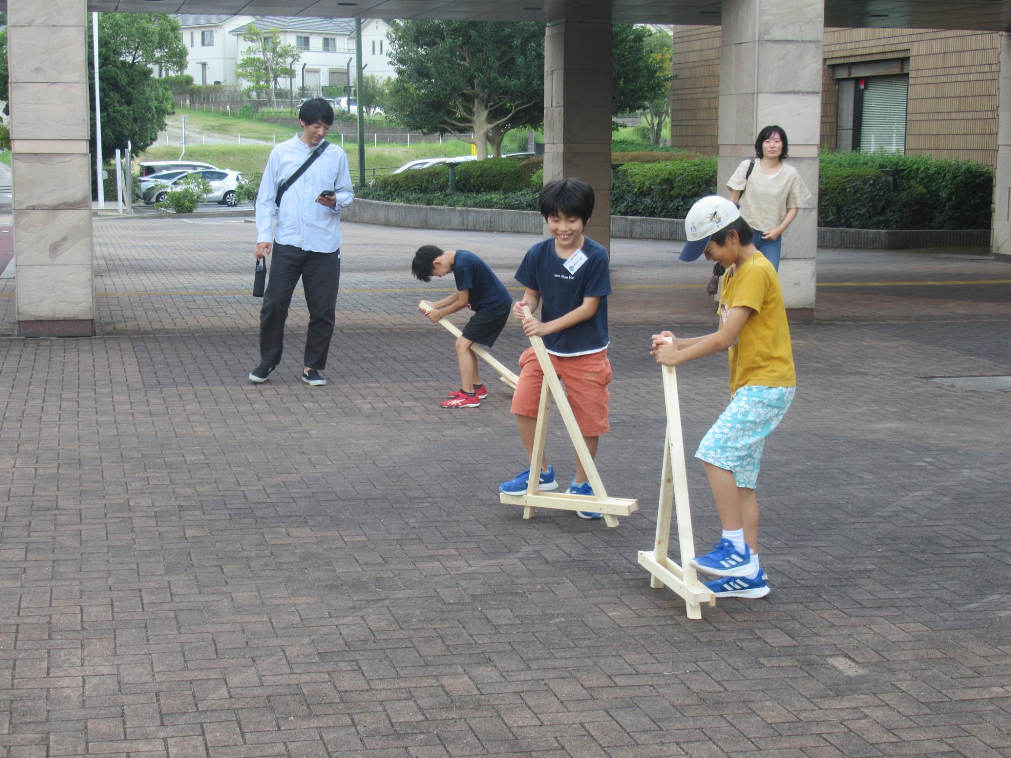 三角竹馬で遊ぶ子どもたち